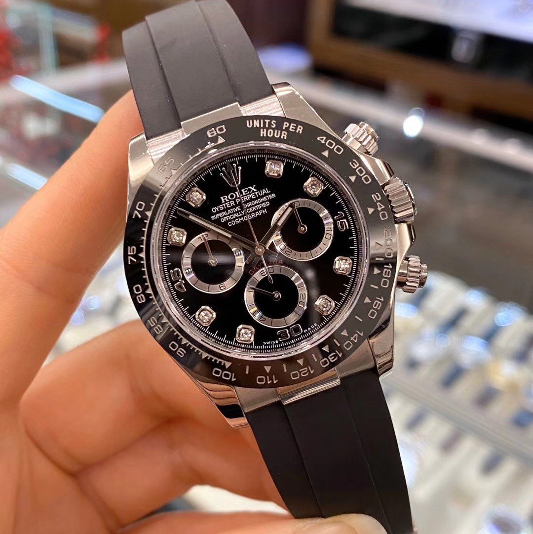 Black dial chronograph-style watch sample held in hand