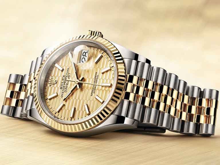 Two-tone Datejust-style watch with patterned dial, fluted bezel and date display