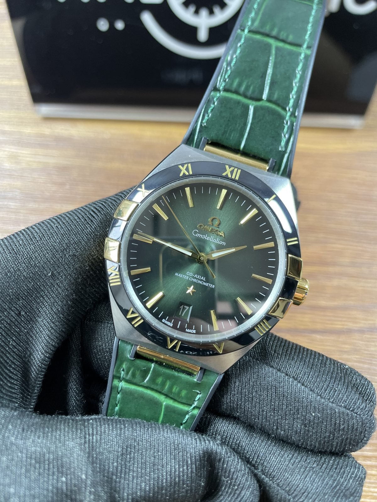 Omega Constellation green dial replica angled front view with gold tone hands indexes and four claws