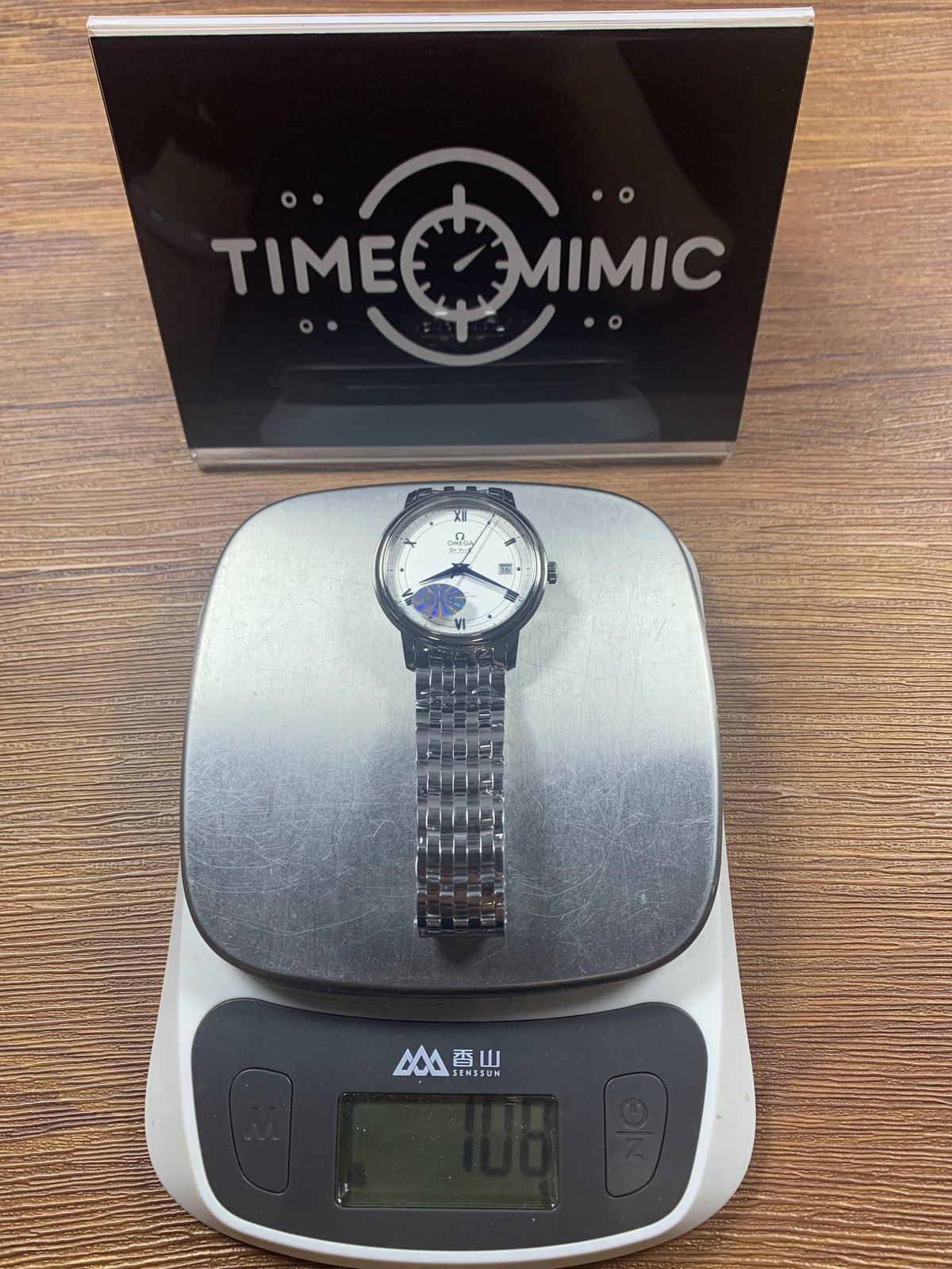 Omega De Ville replica complete watch on digital scale reading about 108 grams with films and sticker present