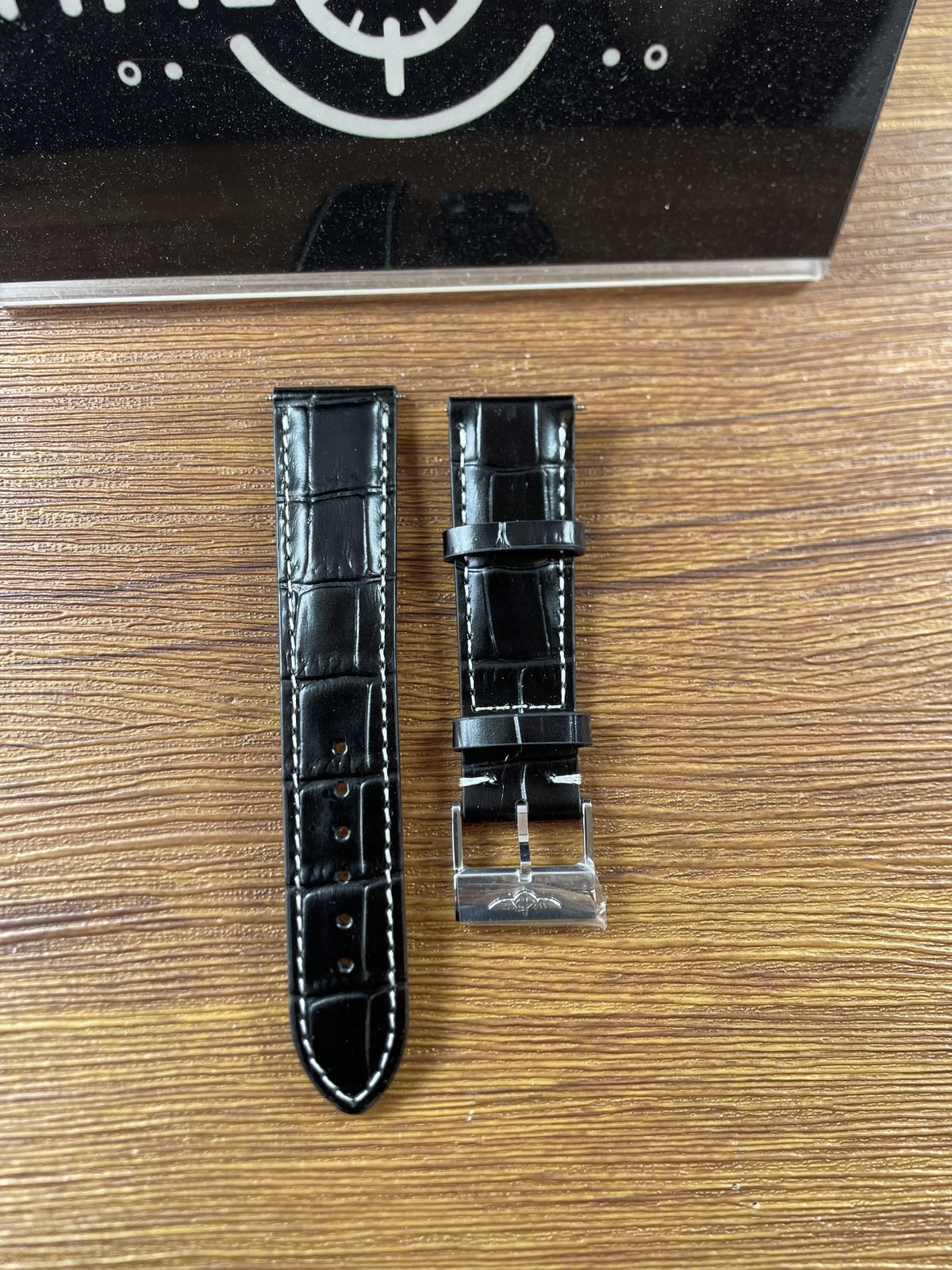 Breitling Navitimer AB0138211B1A1 replica separate black embossed white-stitched strap and tang-style buckle front