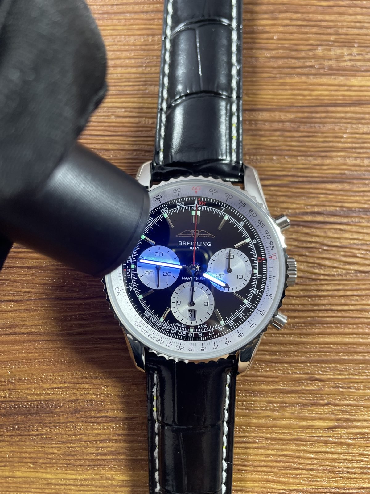 Breitling Navitimer AB0138211B1P1 replica blue hand and green hour-marker lume response under ultraviolet-style light