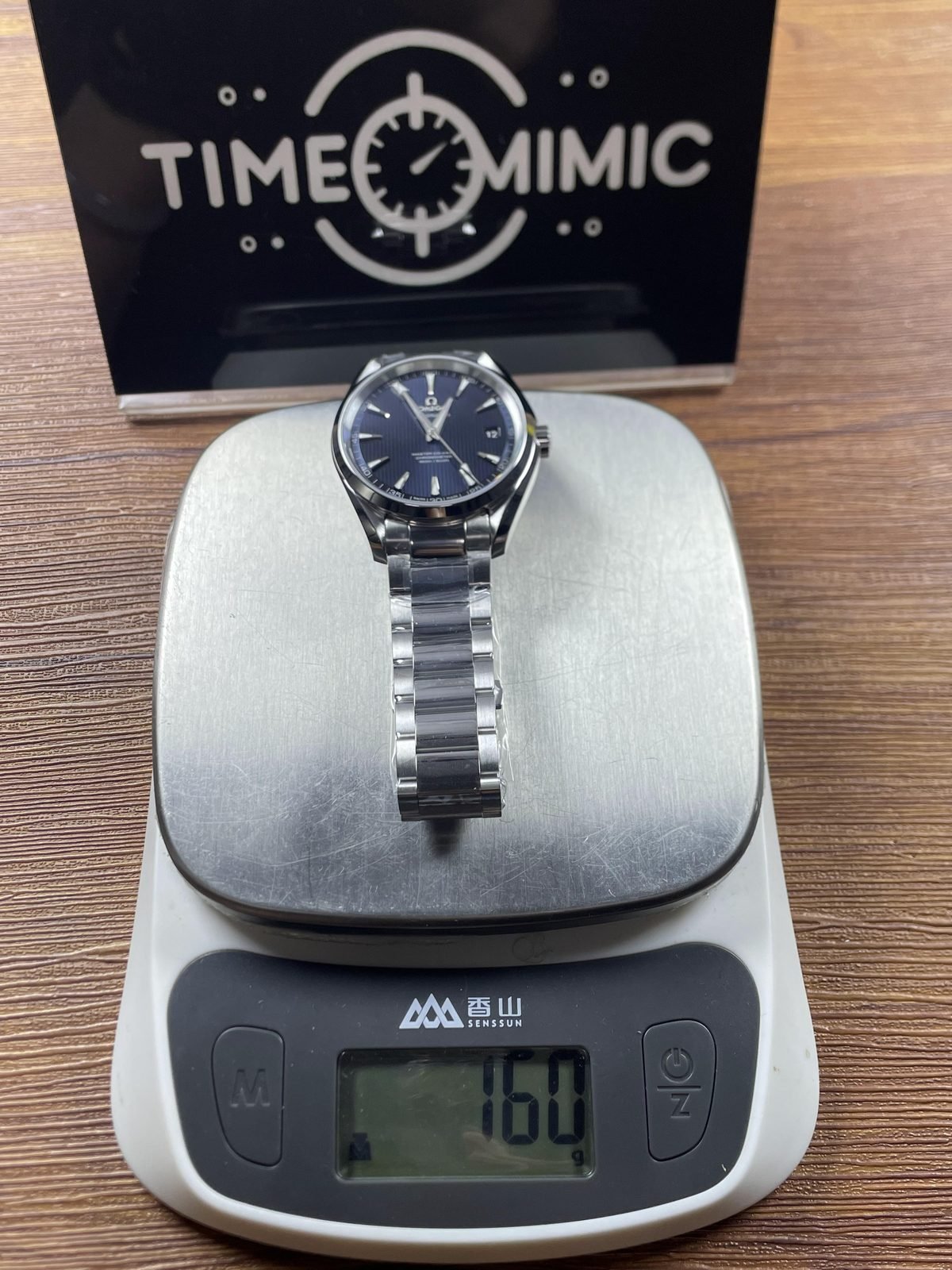 Complete steel tone bracelet watch on scale reading about 160 grams
