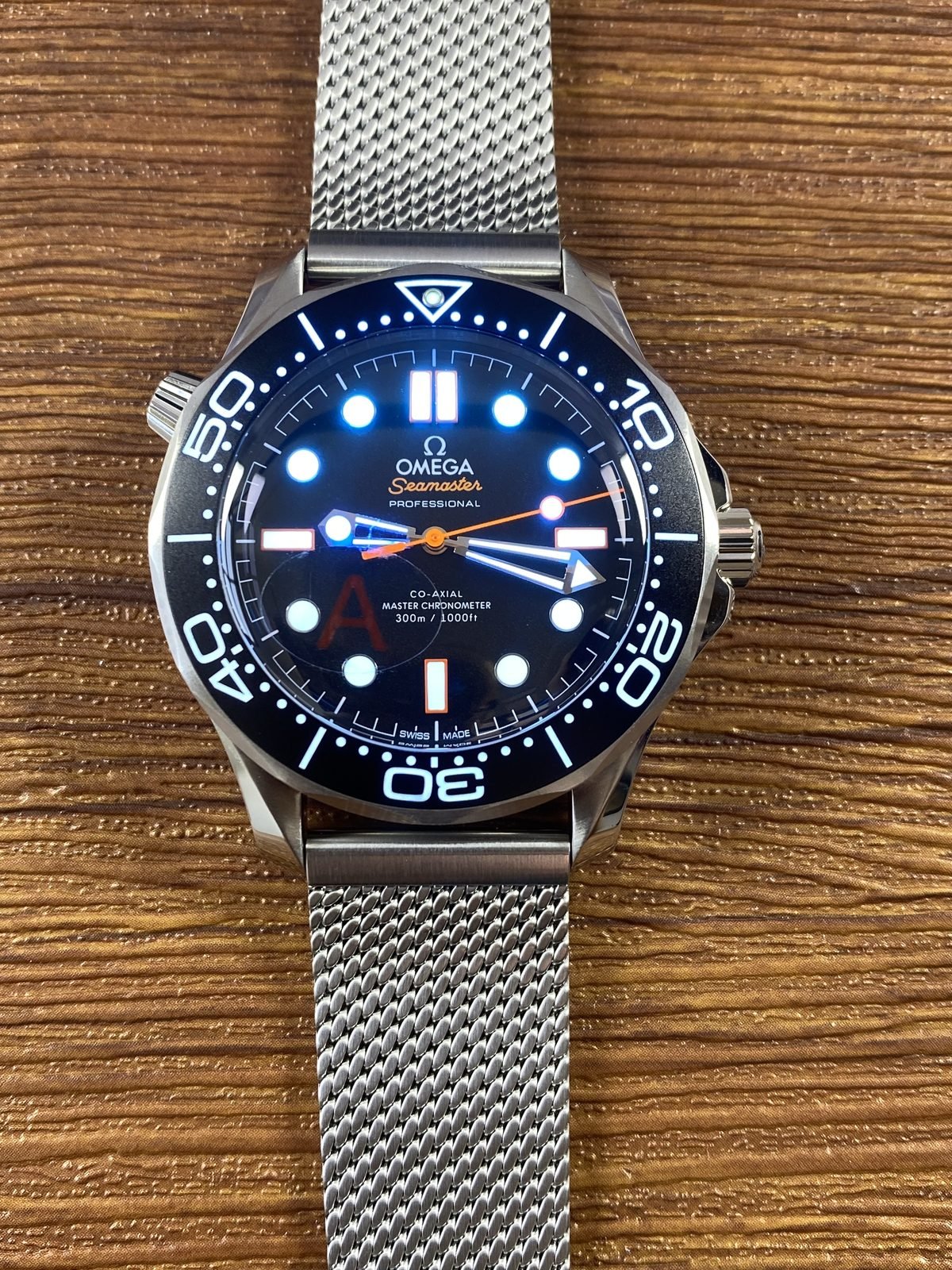 Black and orange no date Seamaster style dial showing immediate blue green luminous response
