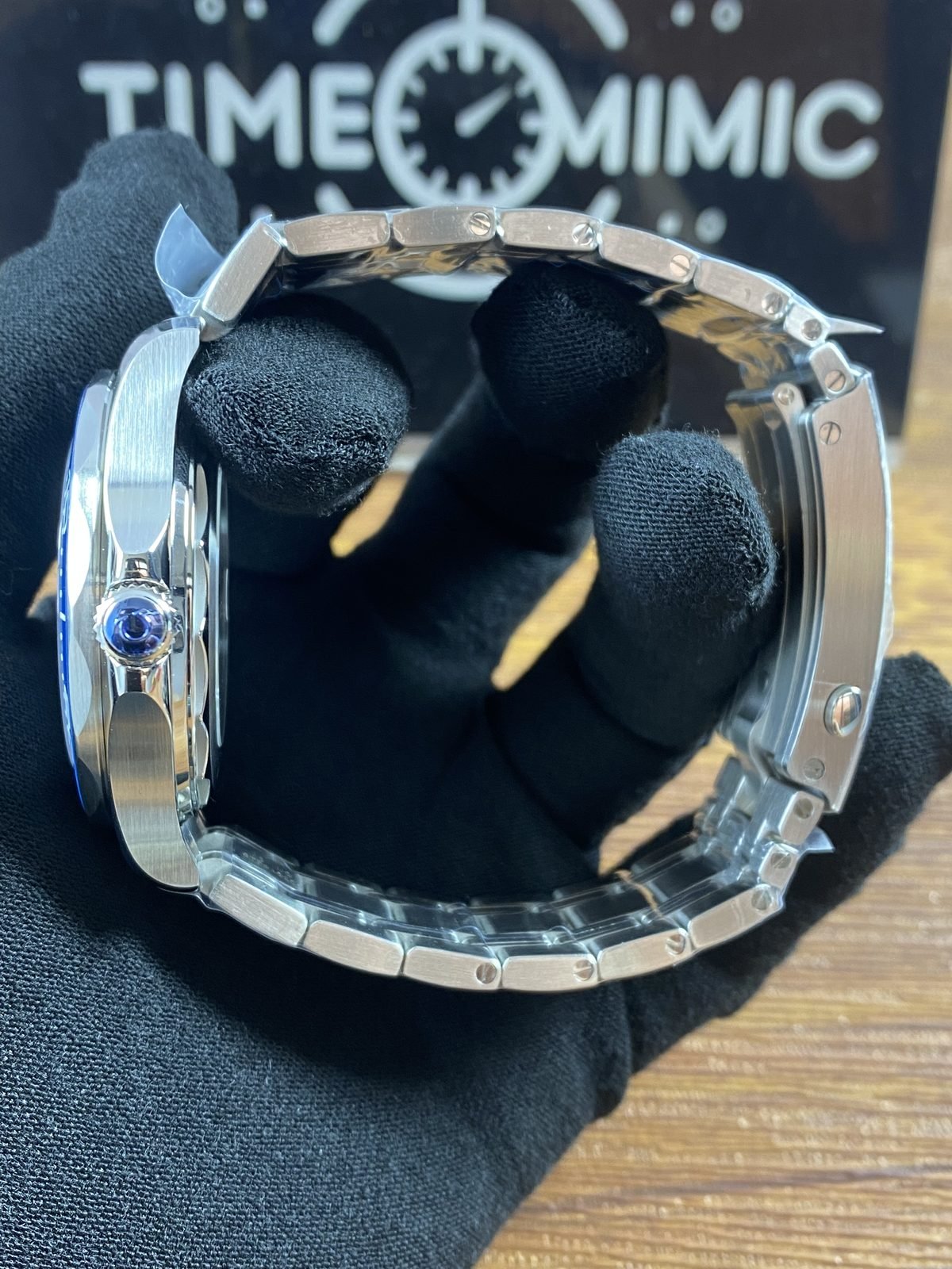 Crown side profile of blue Seamaster style replica with steel tone bracelet