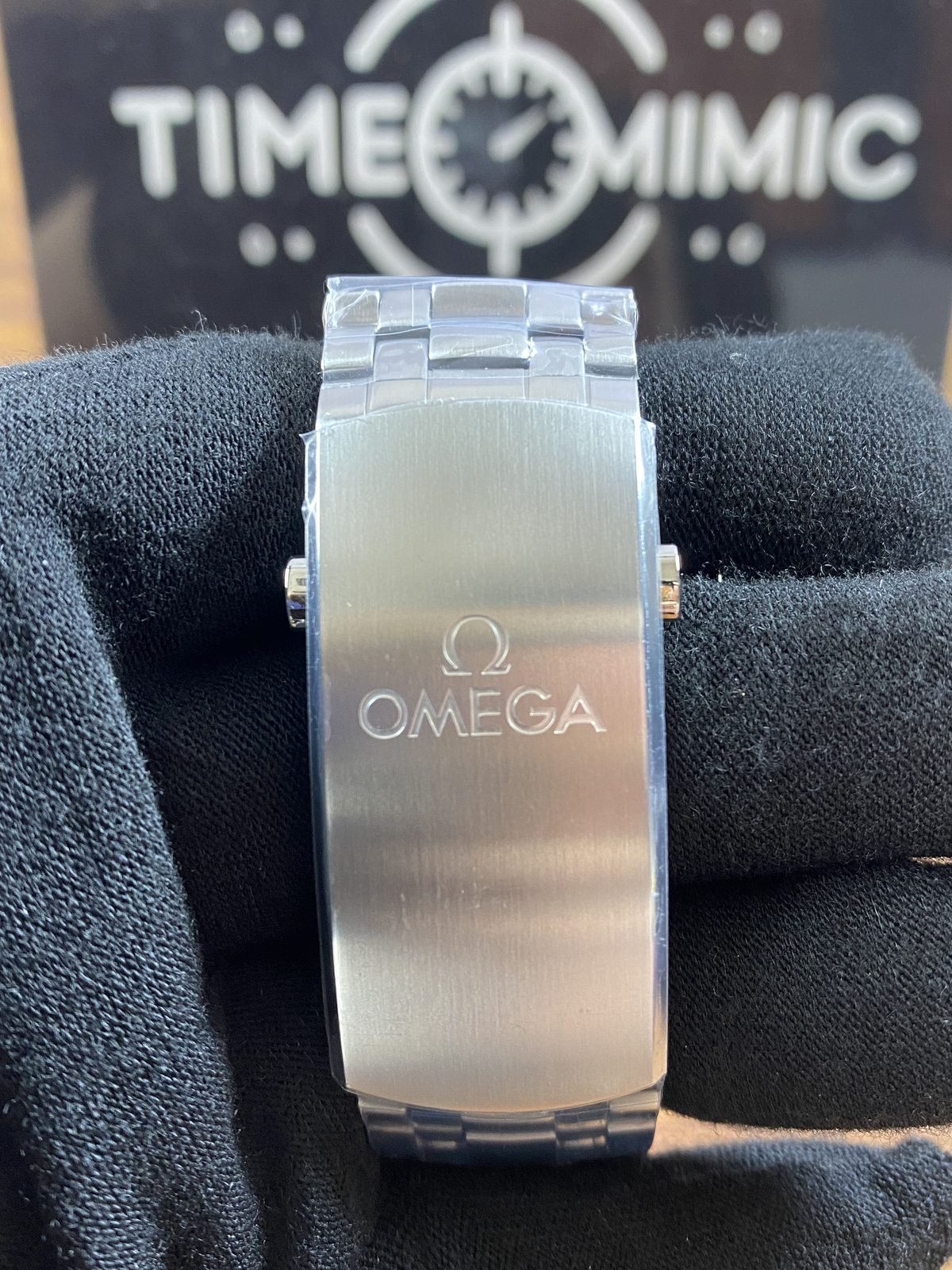 Broad brushed Omega style foldover clasp exterior on steel tone bracelet