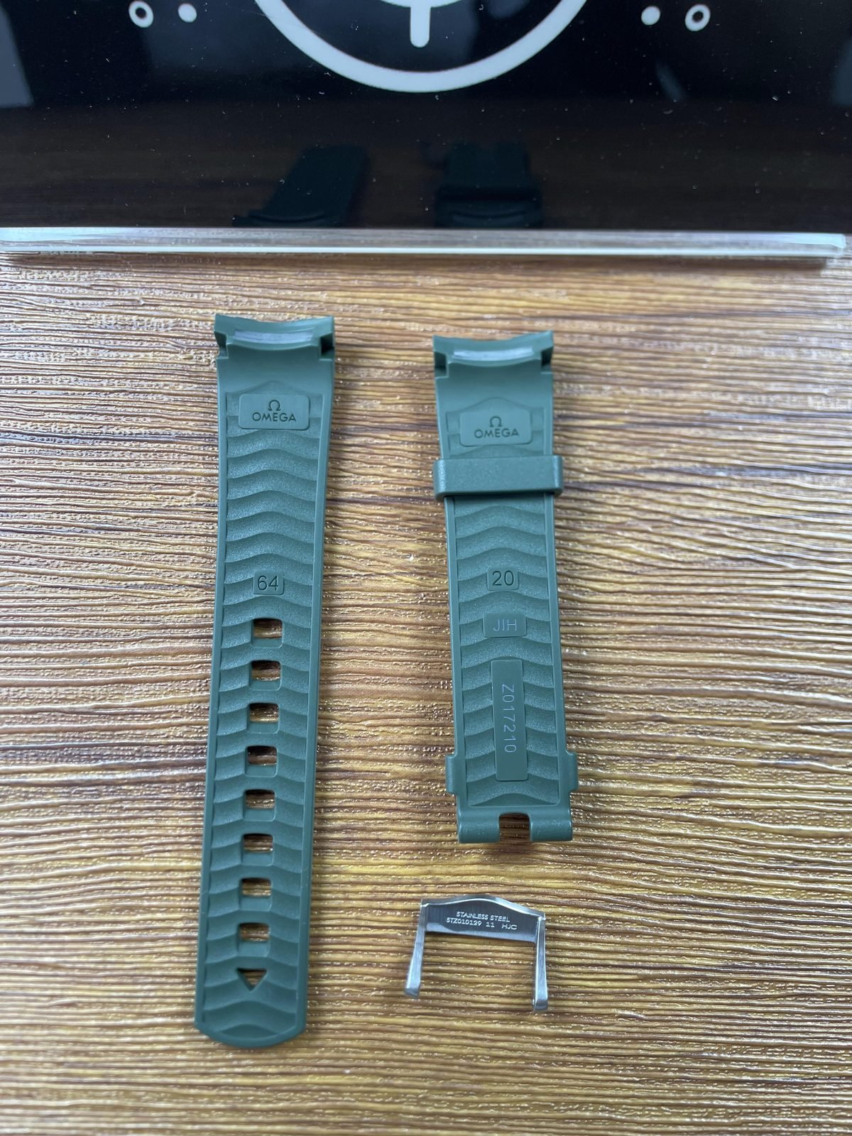Undersides of green strap pieces with 64 20 JJH Z017210 style marks and loose STZ010129 metal part