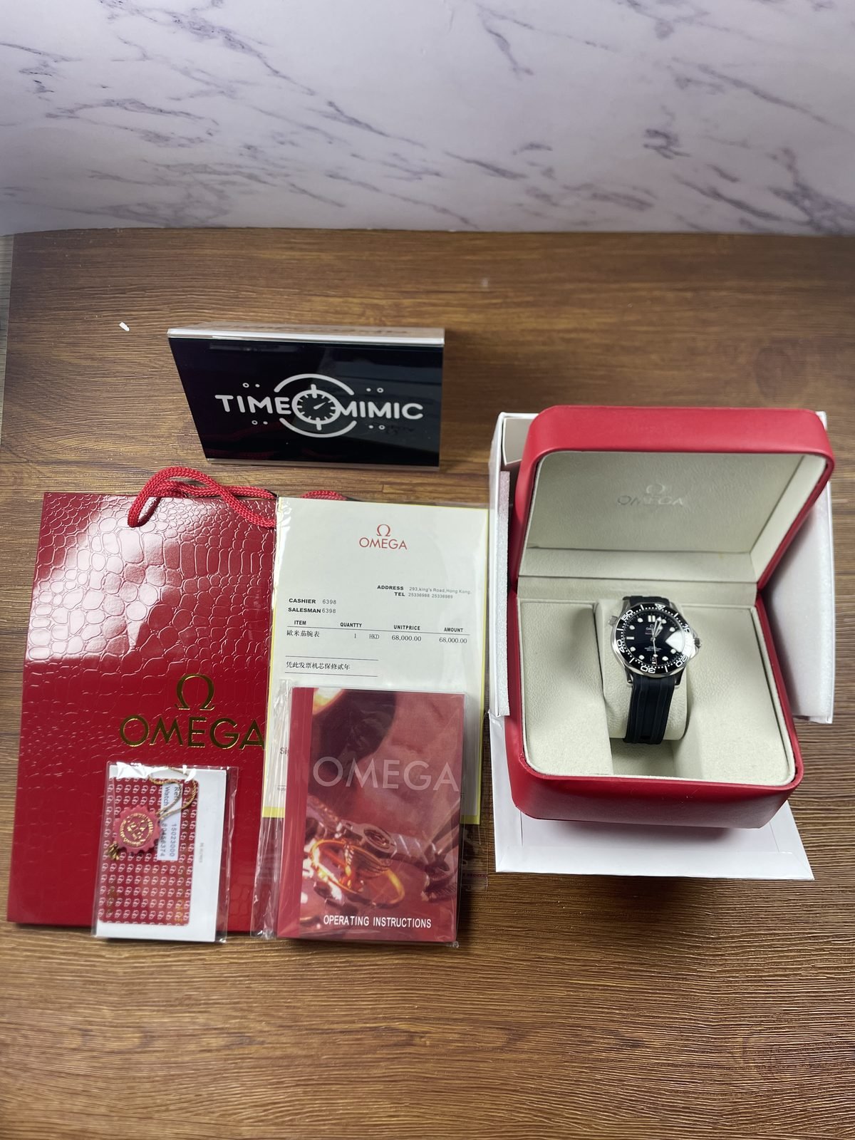 Black strap Seamaster style replica in red white presentation scene with box bag booklet cards and receipt like paper