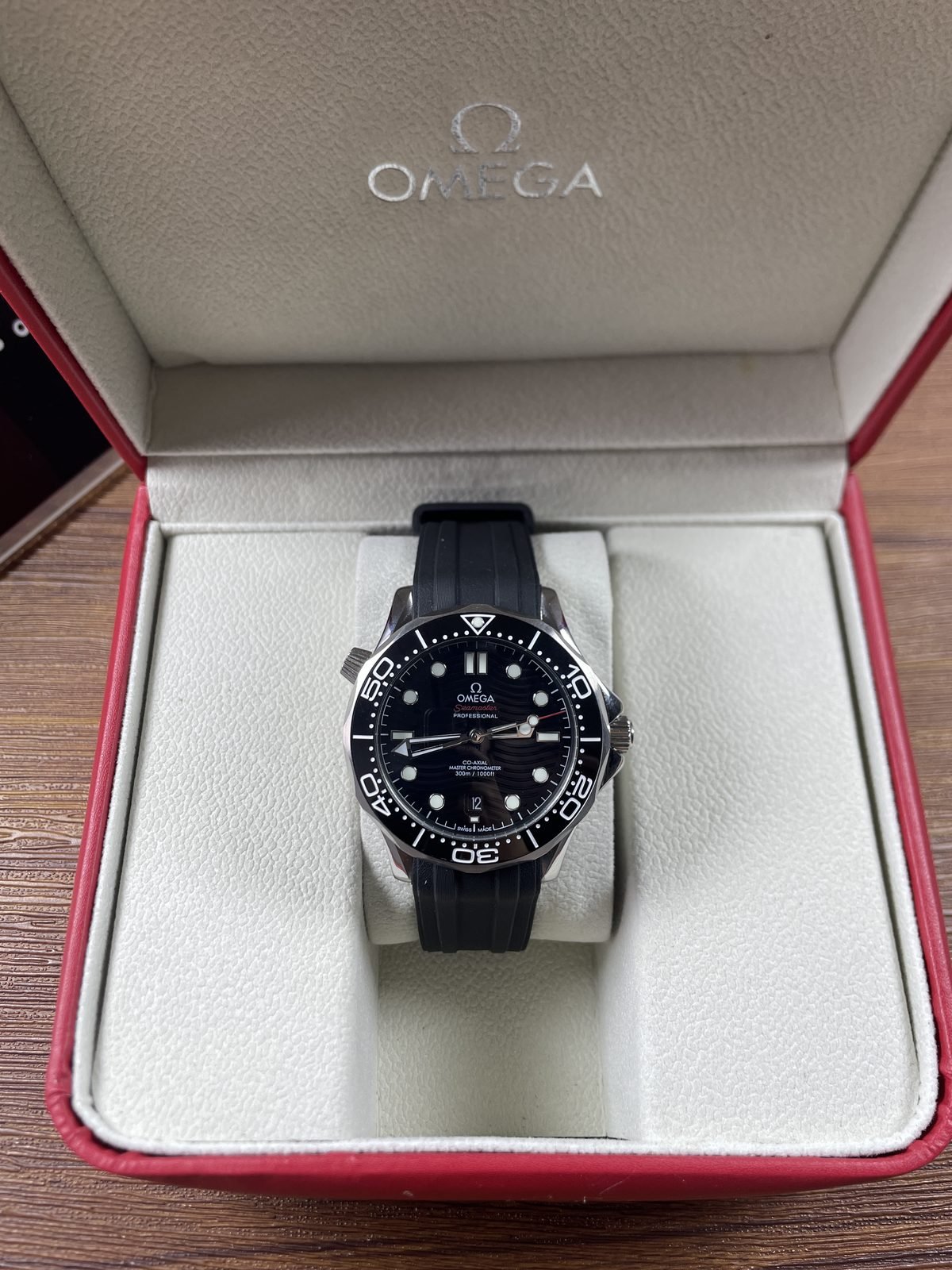 Black wave pattern style Seamaster replica dial with black bezel red accents date at six and black strap
