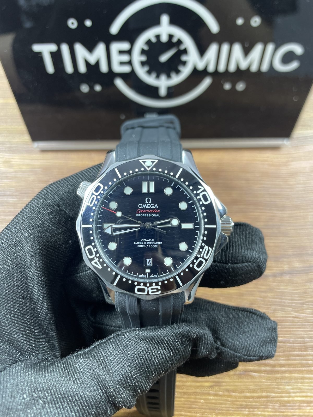 Centered black wave style dial and black bezel Omega Seamaster 210.32.42.20.01.001 style replica on black grooved strap