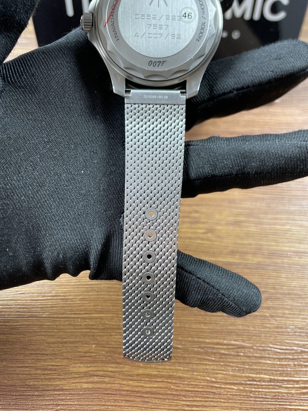Military style solid caseback with broad arrow 007 Diver 300M and number style markings plus mesh adjustment fasteners