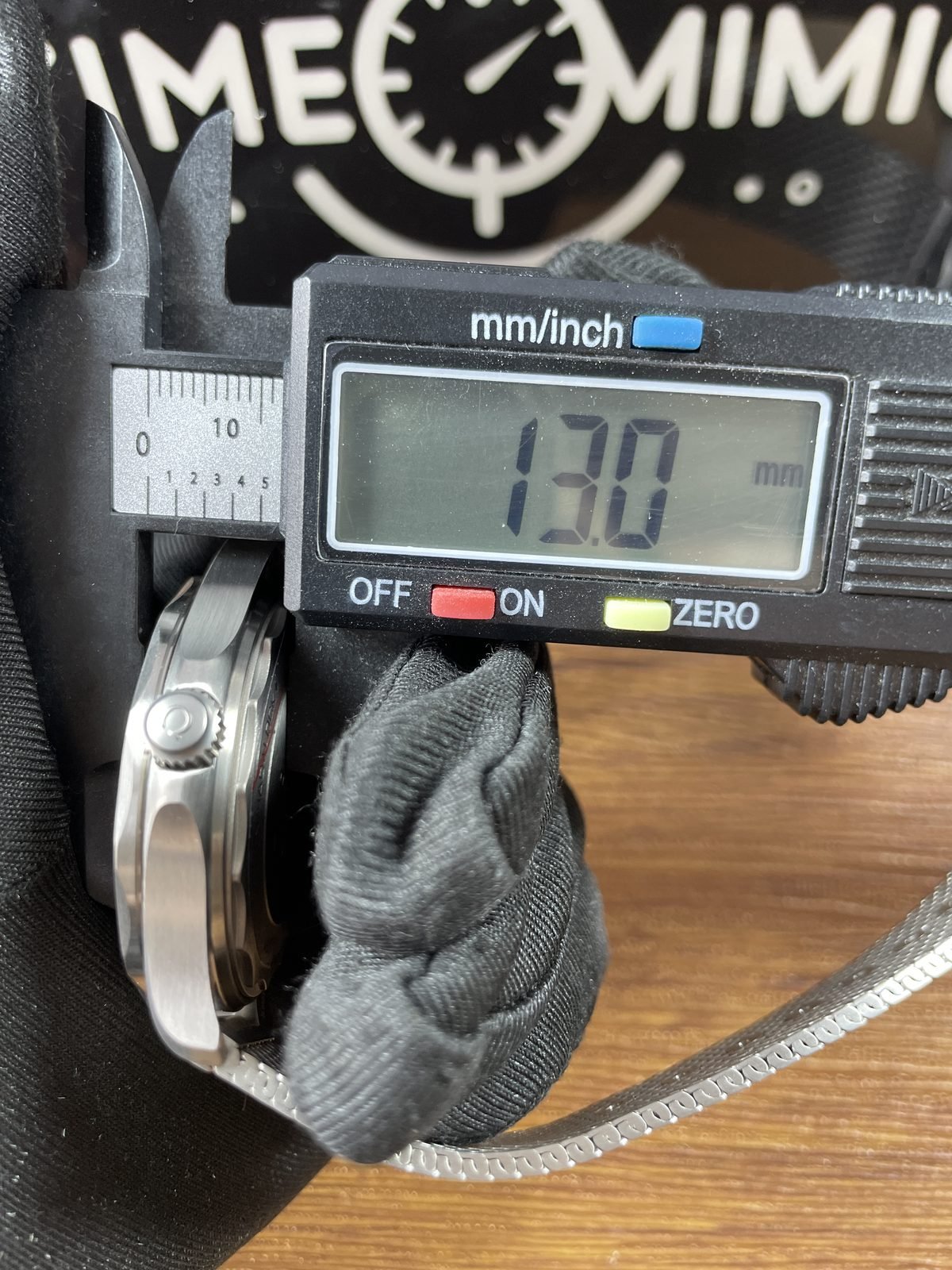 Digital calliper displaying approximately 13.0 millimetres in thickness direction of 007 style Seamaster replica