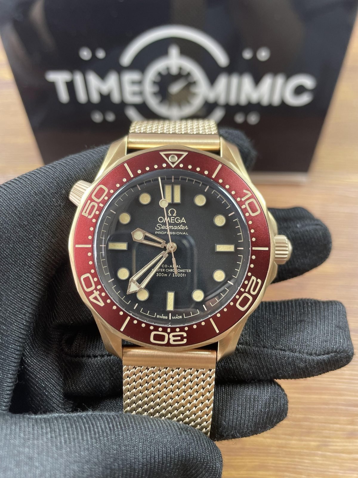 Warm bronze gold tone no-date Seamaster 210.92.42.20.01.003 style replica with black dial burgundy bezel and mesh bracelet