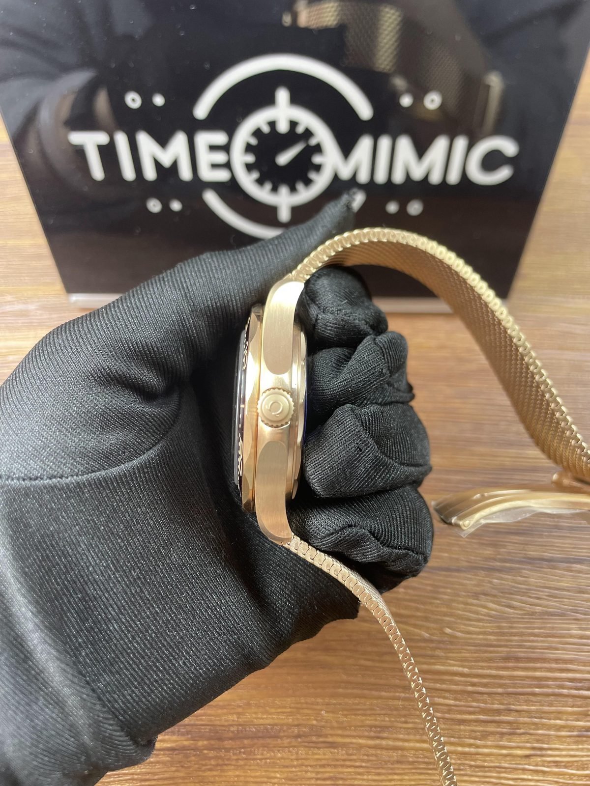 Crown side profile of warm bronze gold tone Seamaster replica with fine mesh bracelet and filmed clasp