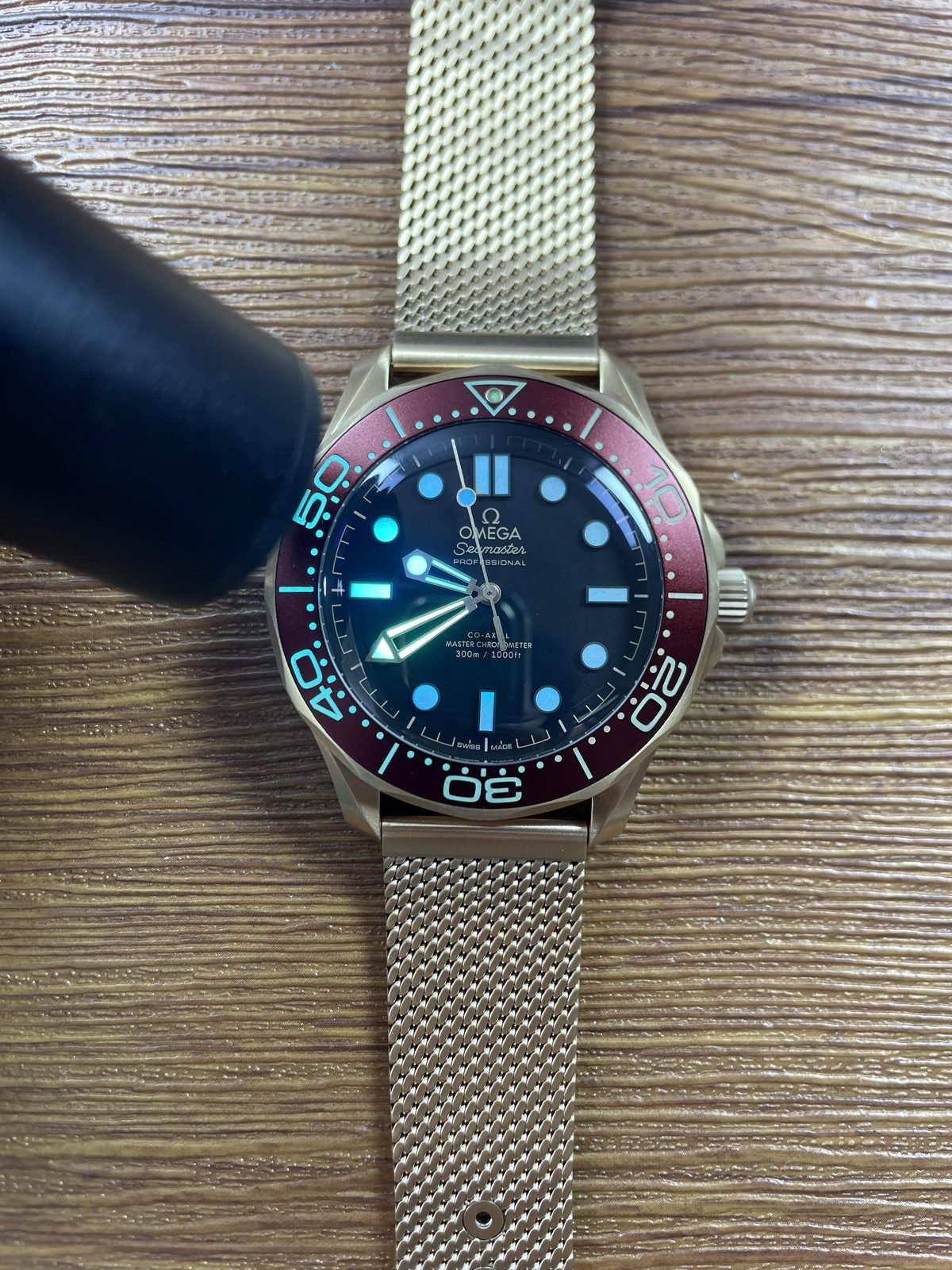 Immediate blue cyan and green luminous style response on black no-date dial and burgundy bezel Seamaster replica