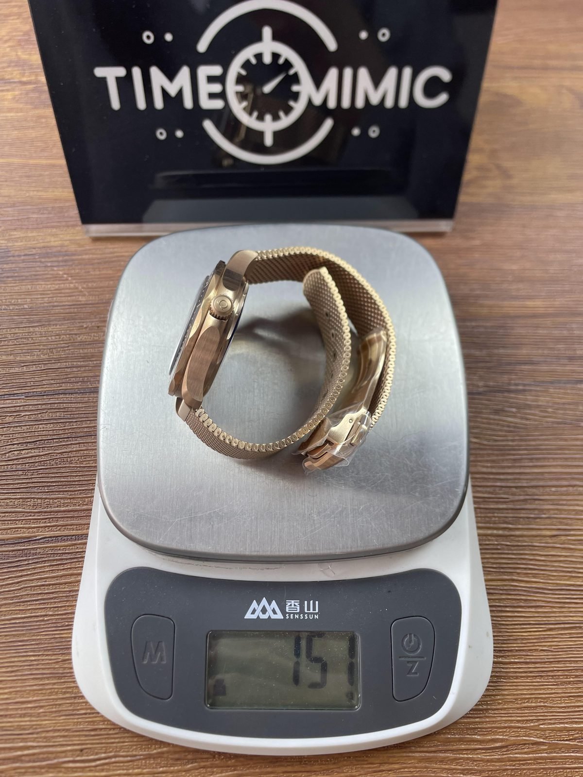 Warm tone mesh bracelet Seamaster replica on scale displaying approximately 157 grams