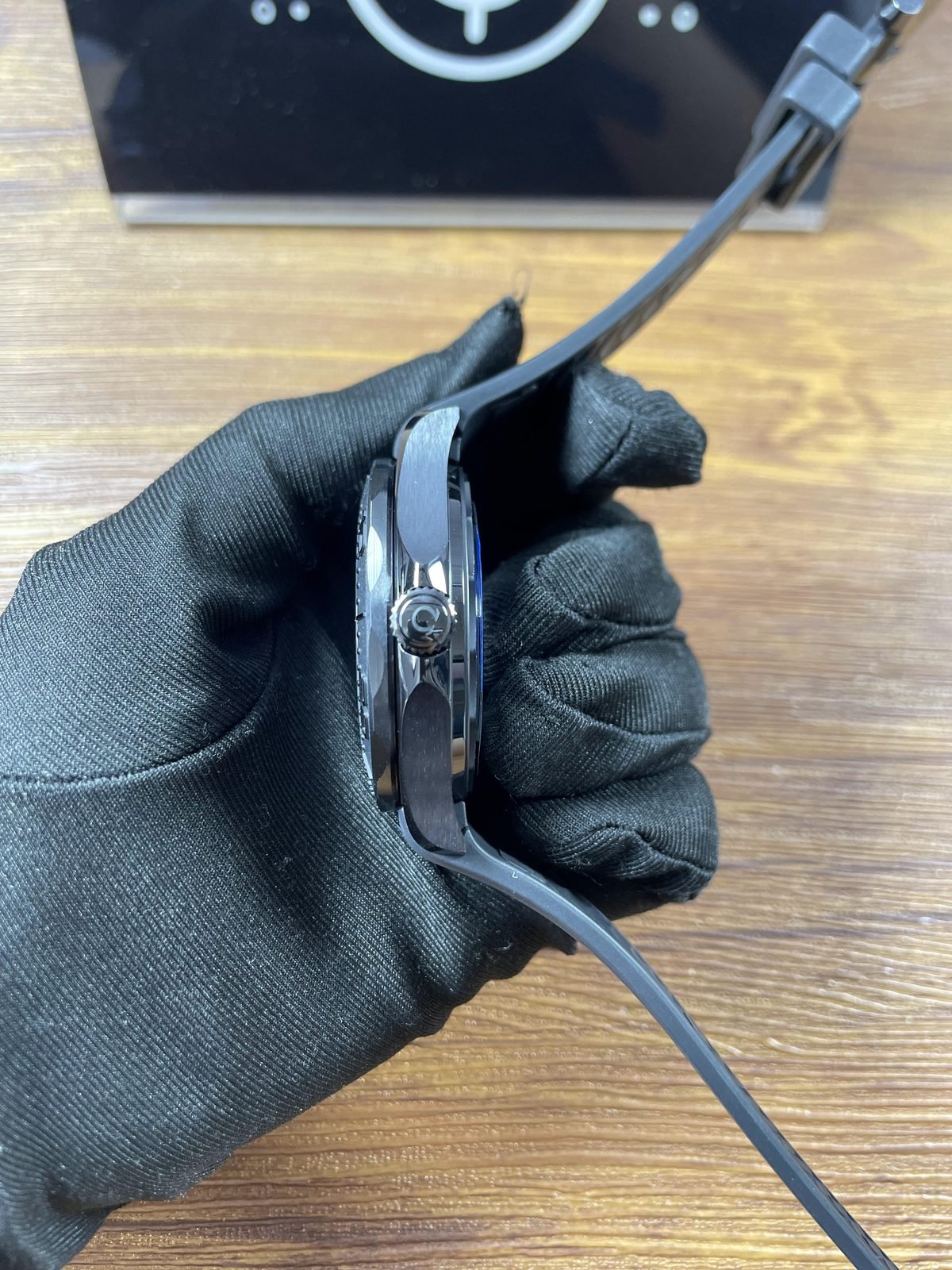 Crown side profile of deep black Seamaster replica case and grooved rubber style strap
