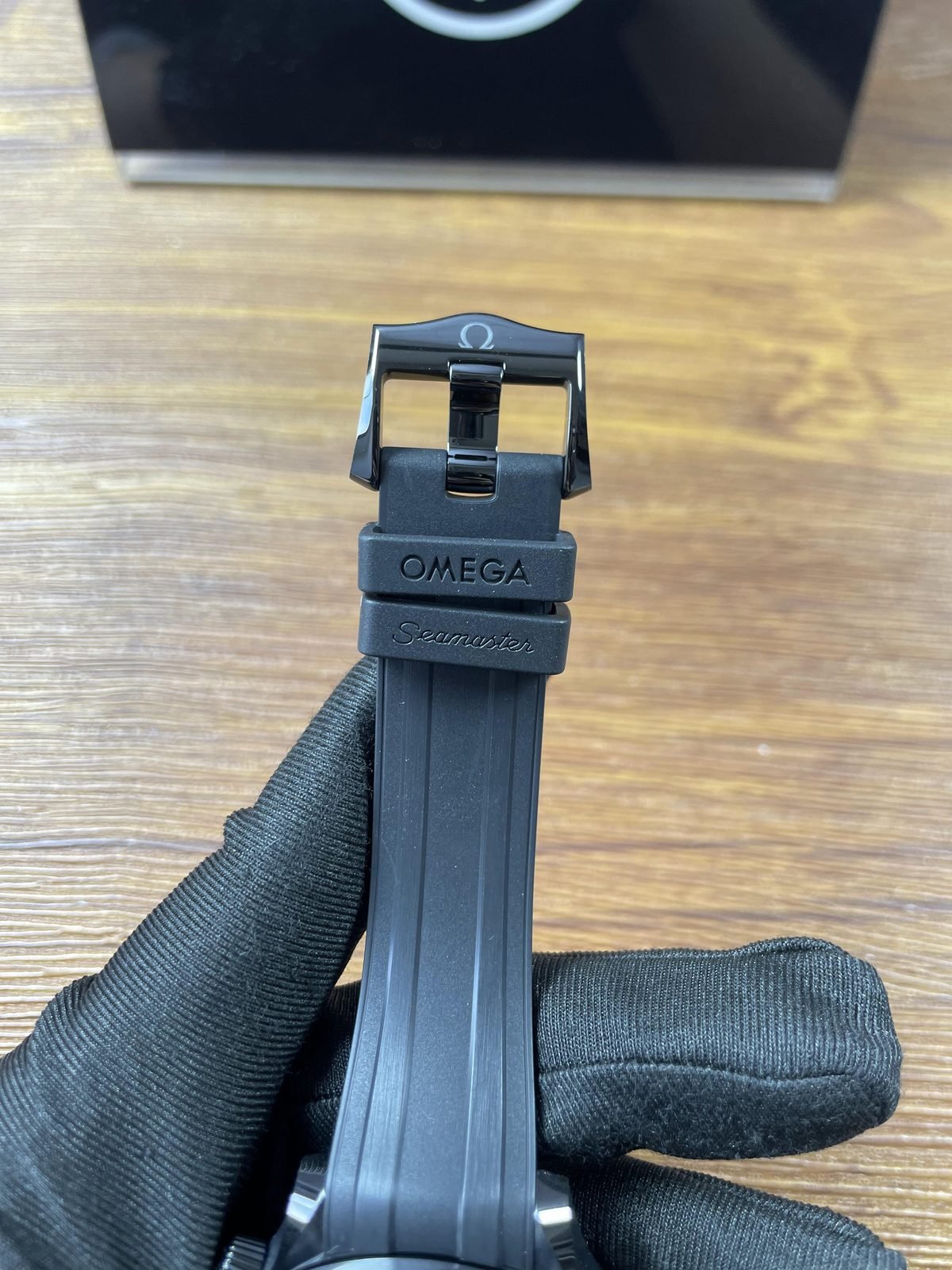High gloss black pin buckle exterior and twin strap keepers on Seamaster replica