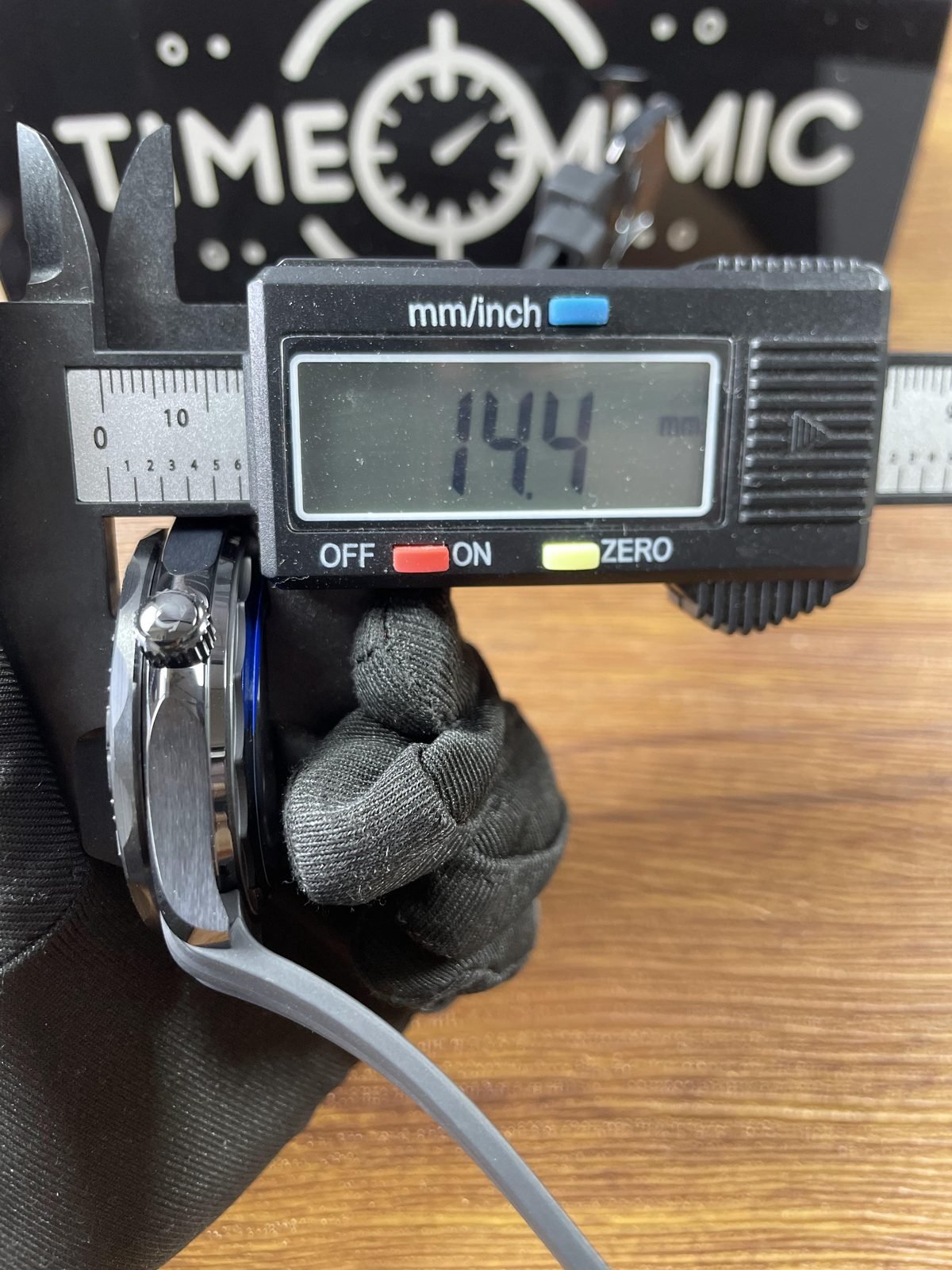Digital calliper displaying approximately 14.4 millimetres in thickness direction of Black Black style Seamaster replica