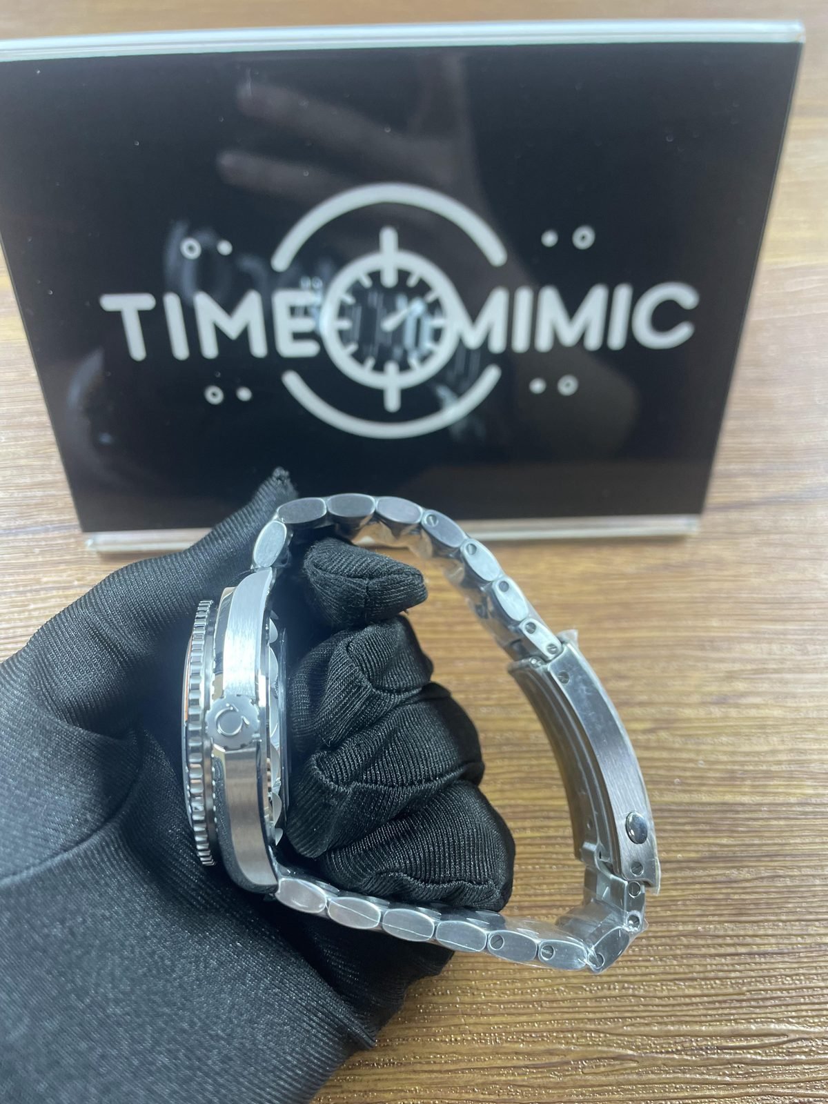 Left side profile of steel tone Planet Ocean replica with valve style control bracelet and open clasp