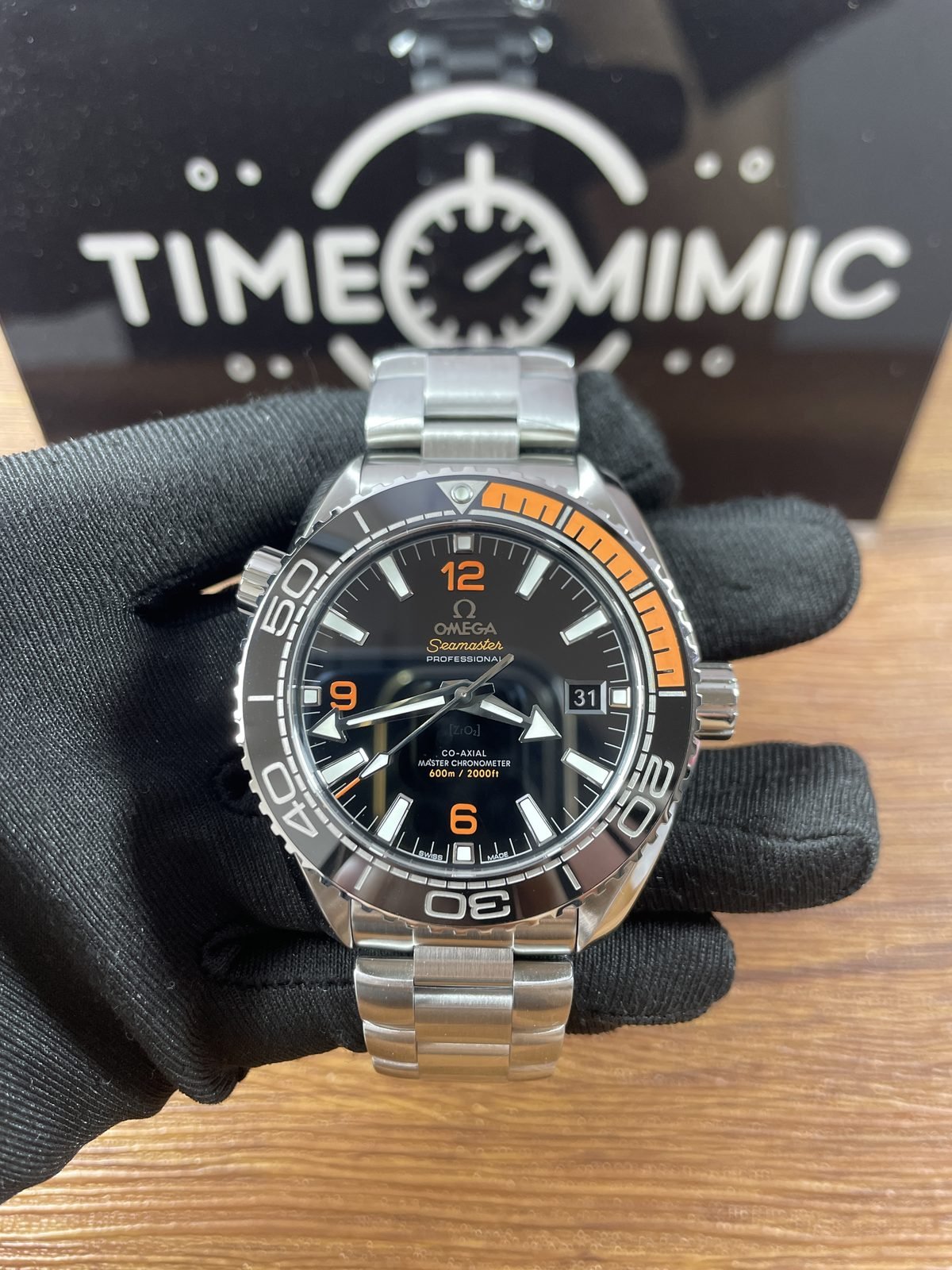 Close front of black and orange Planet Ocean style replica with date appearing as 31