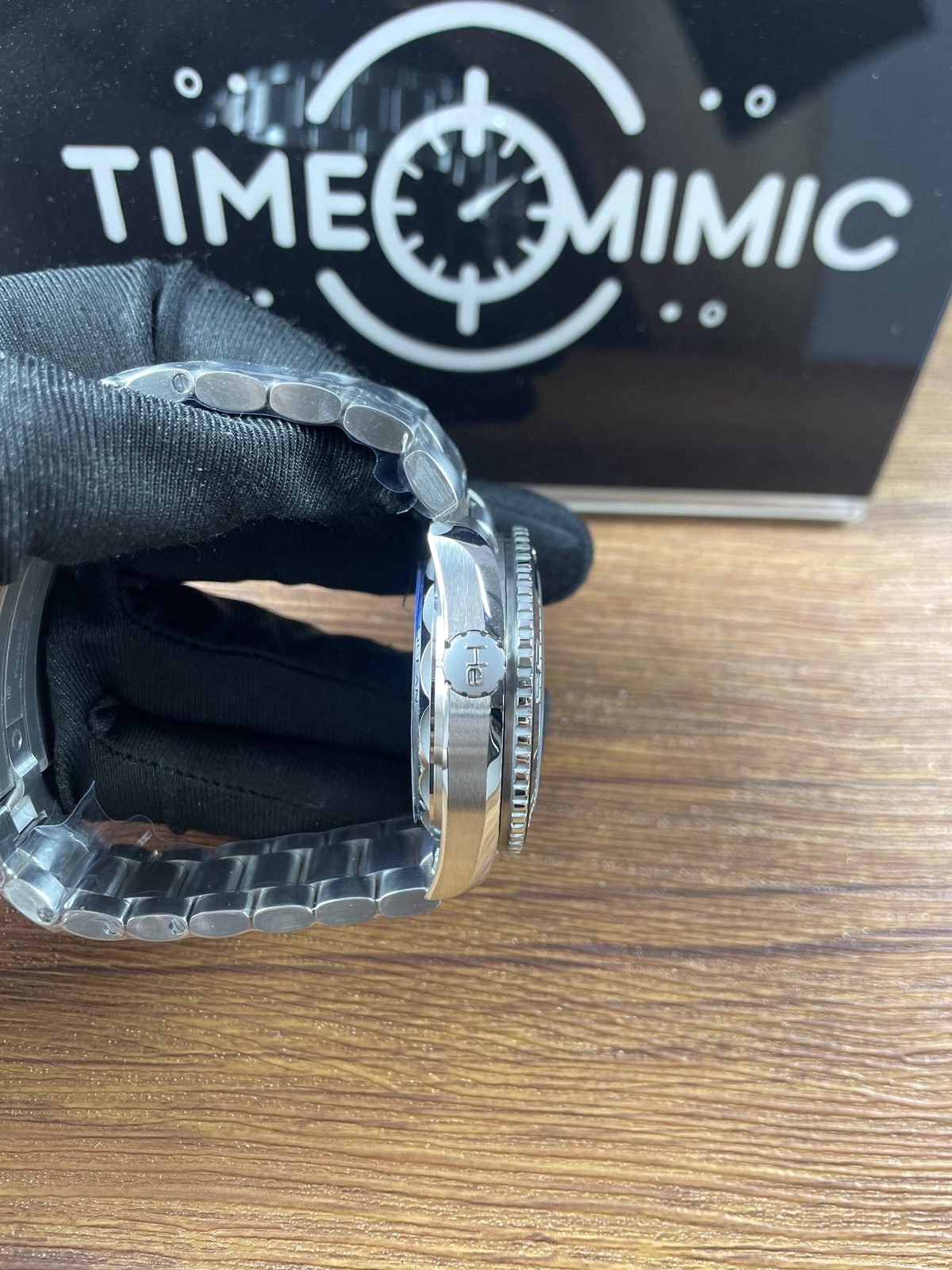 Right side profile of Planet Ocean replica showing crown scalloped bezel case layers and steel tone bracelet