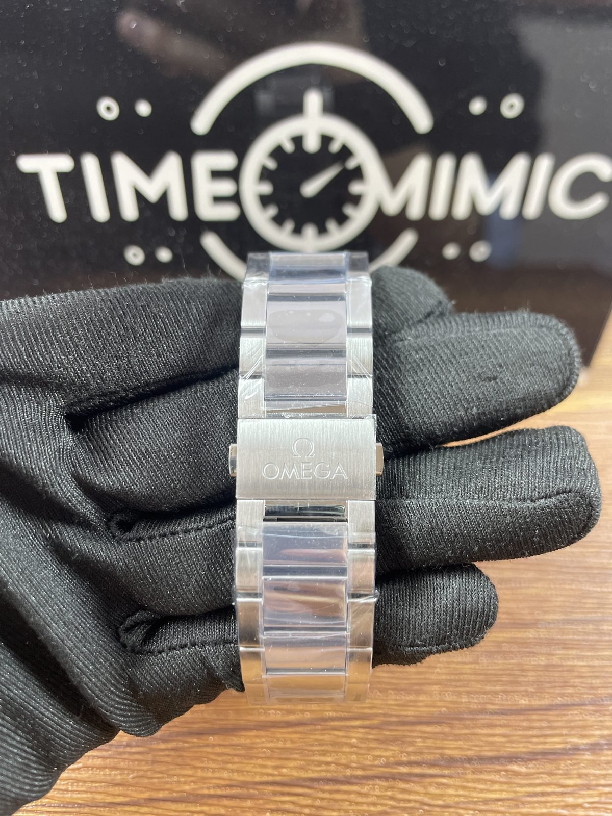 Butterfly clasp exterior of Aqua Terra replica with logo style mark and protective film on bracelet