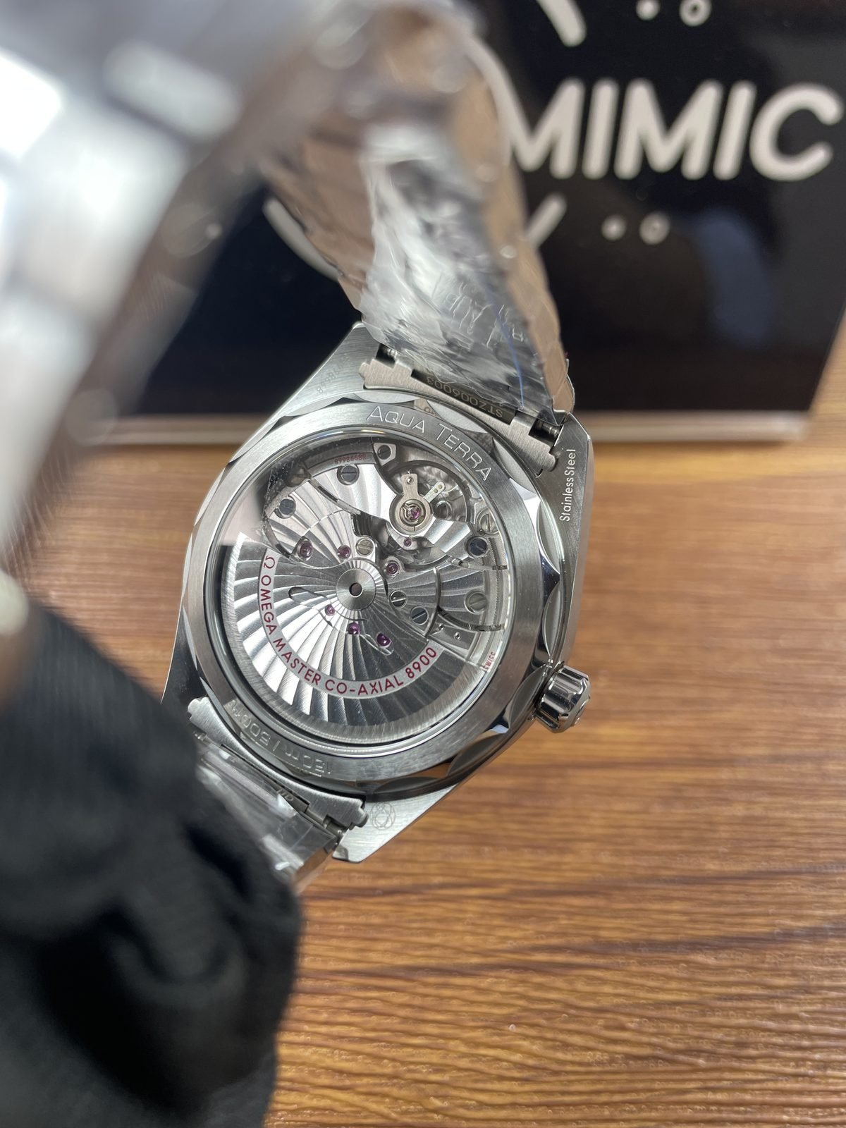 Transparent caseback of black Aqua Terra style replica with decorated automatic looking movement and 8900 style wording