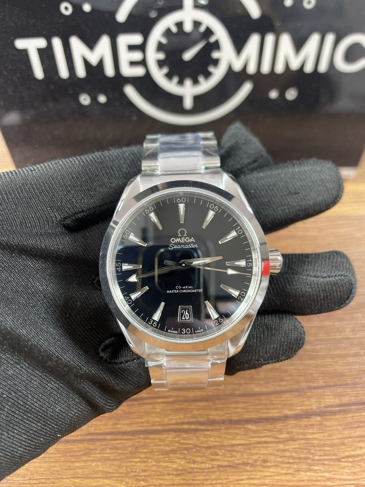 Close front of black horizontal stripe Aqua Terra replica with date 26 and older steel tone bracelet direction