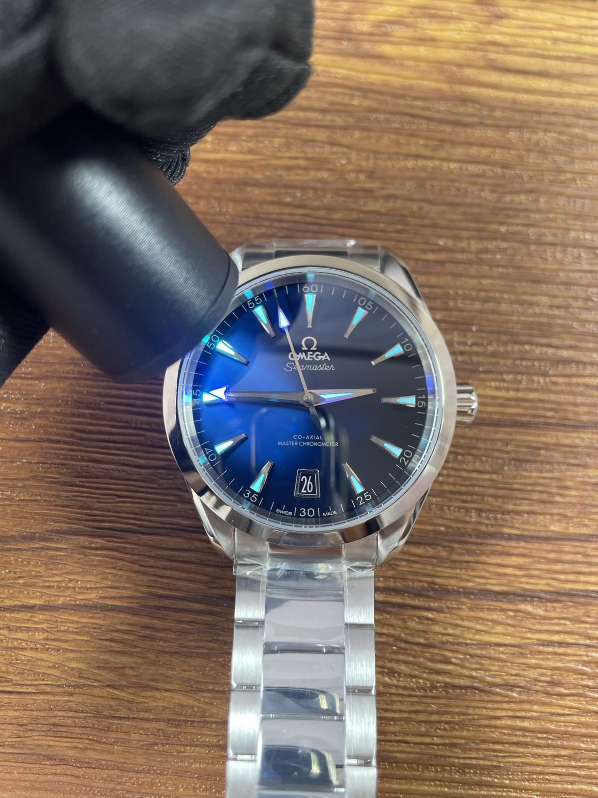 Hands and indexes of black horizontal stripe Aqua Terra replica showing immediate blue cyan luminous style response