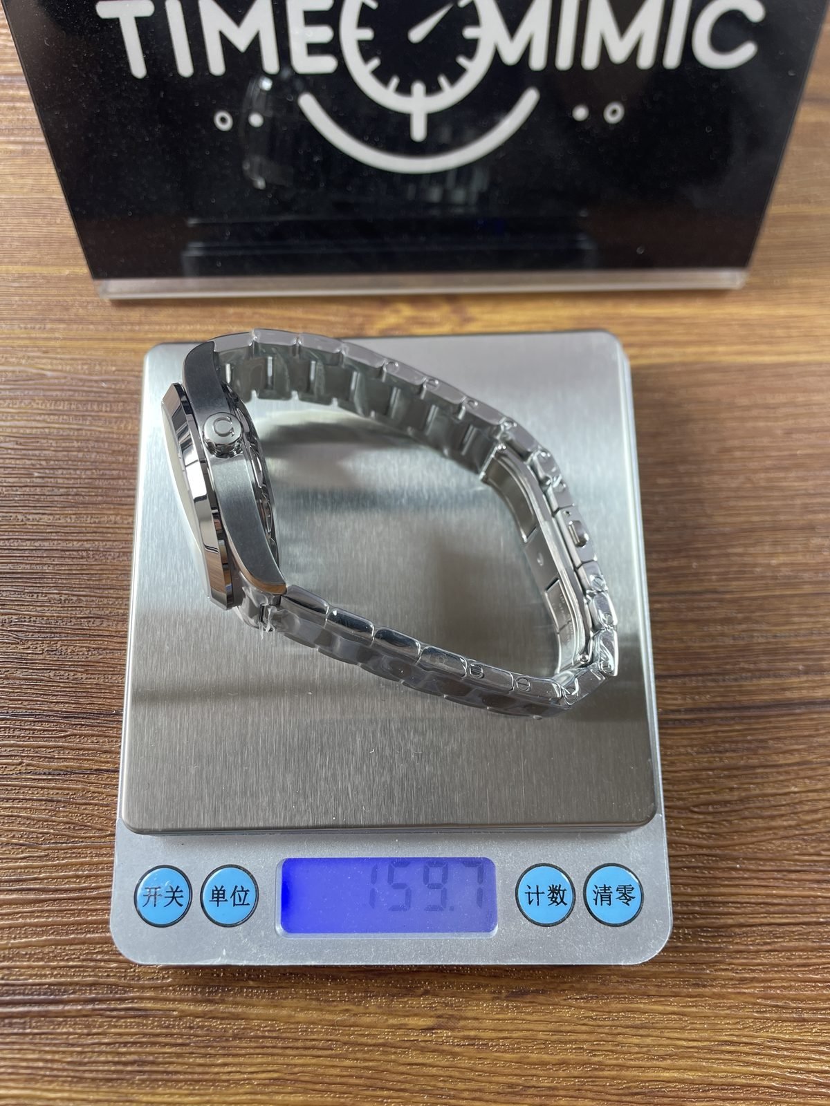 Black horizontal stripe dial Aqua Terra replica on digital scale displaying about 159.7 grams