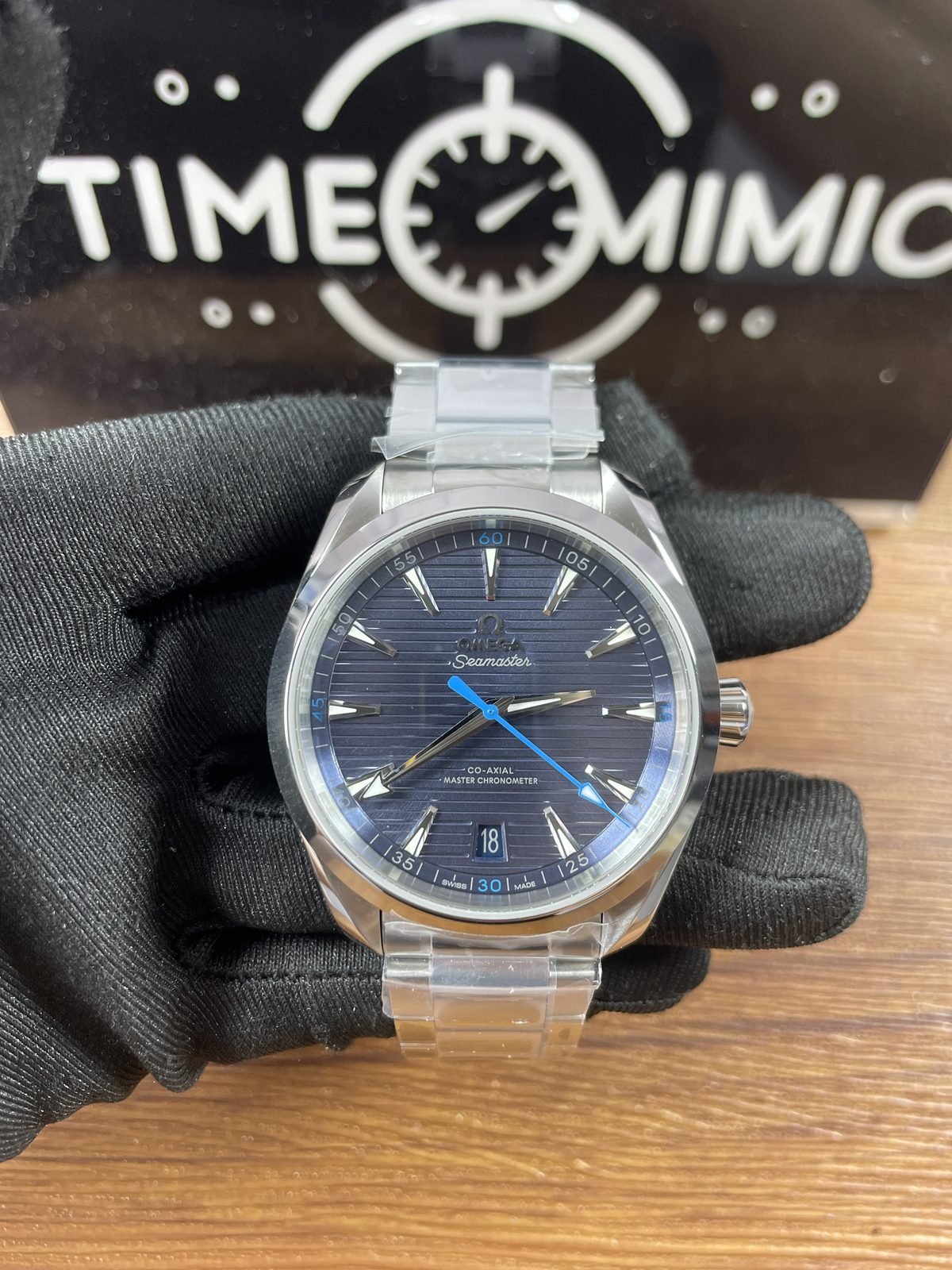 Close front of blue horizontal stripe Aqua Terra replica with blue seconds hand quarter numbers and date 18