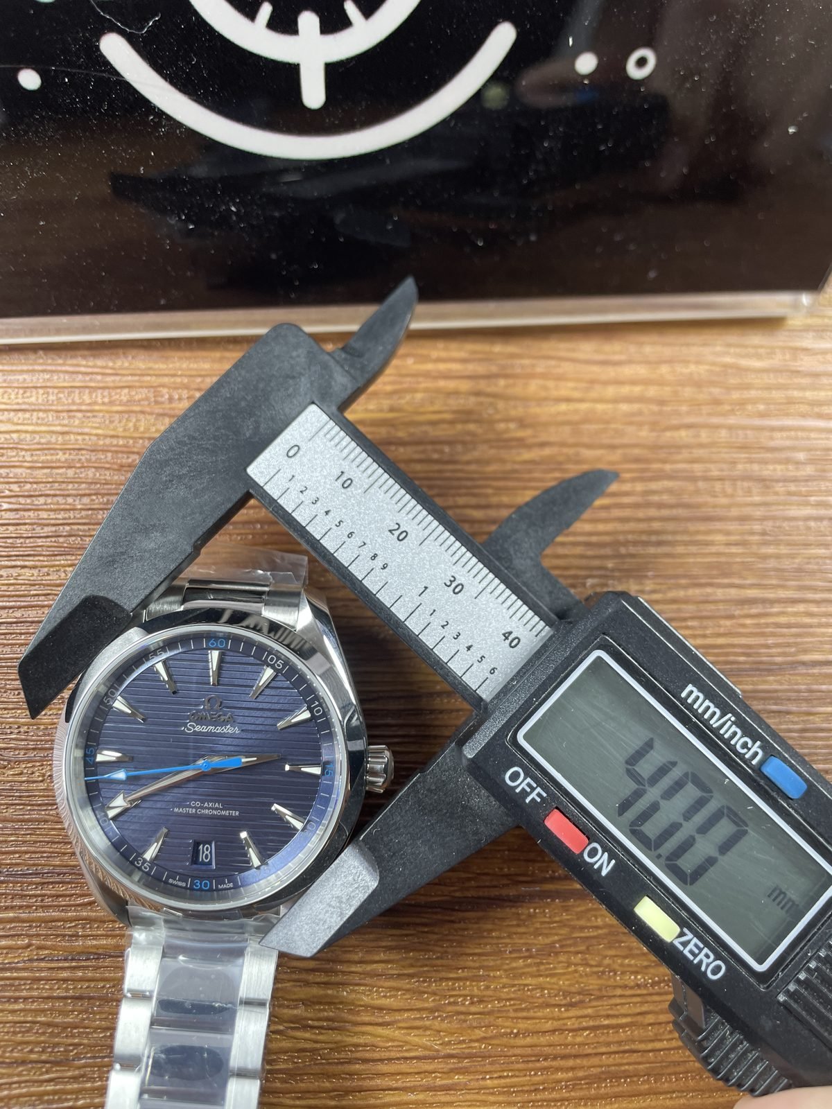 Digital calliper displaying about 40.0 millimetres across the case body of blue Aqua Terra replica