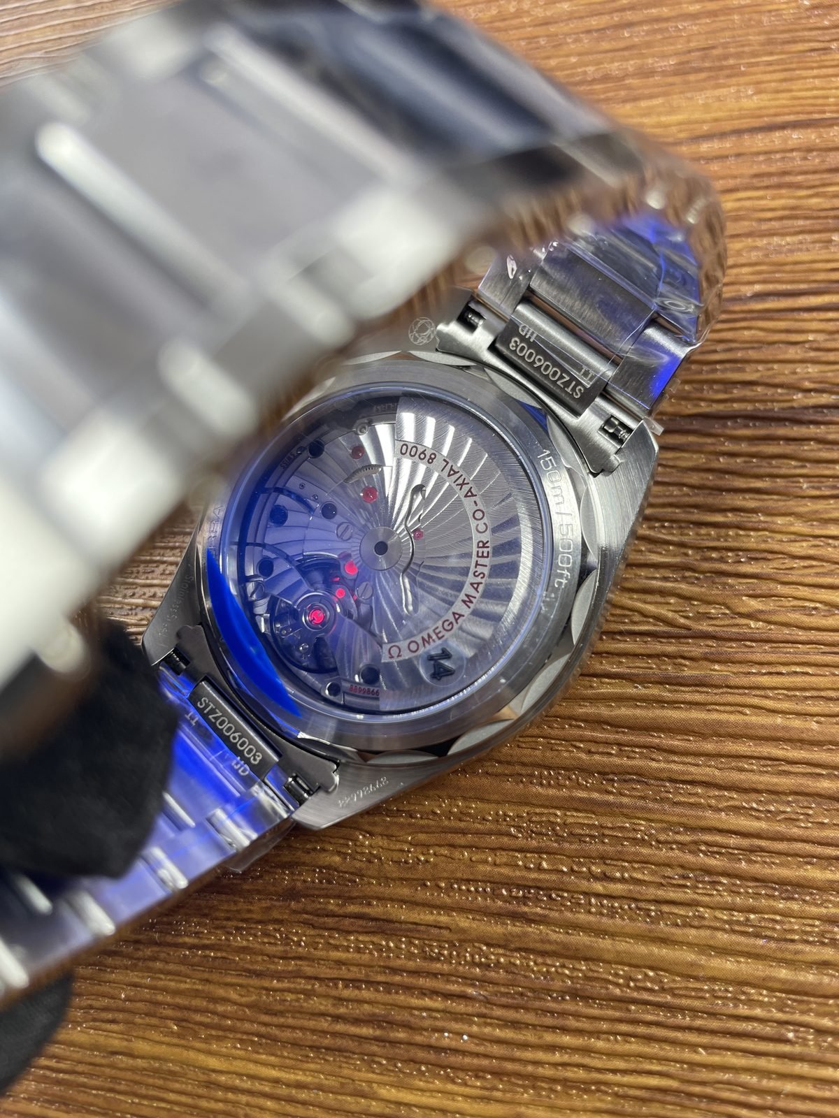Illuminated transparent back of blue Aqua Terra replica with 8900 Aqua Terra 150m and code style markings