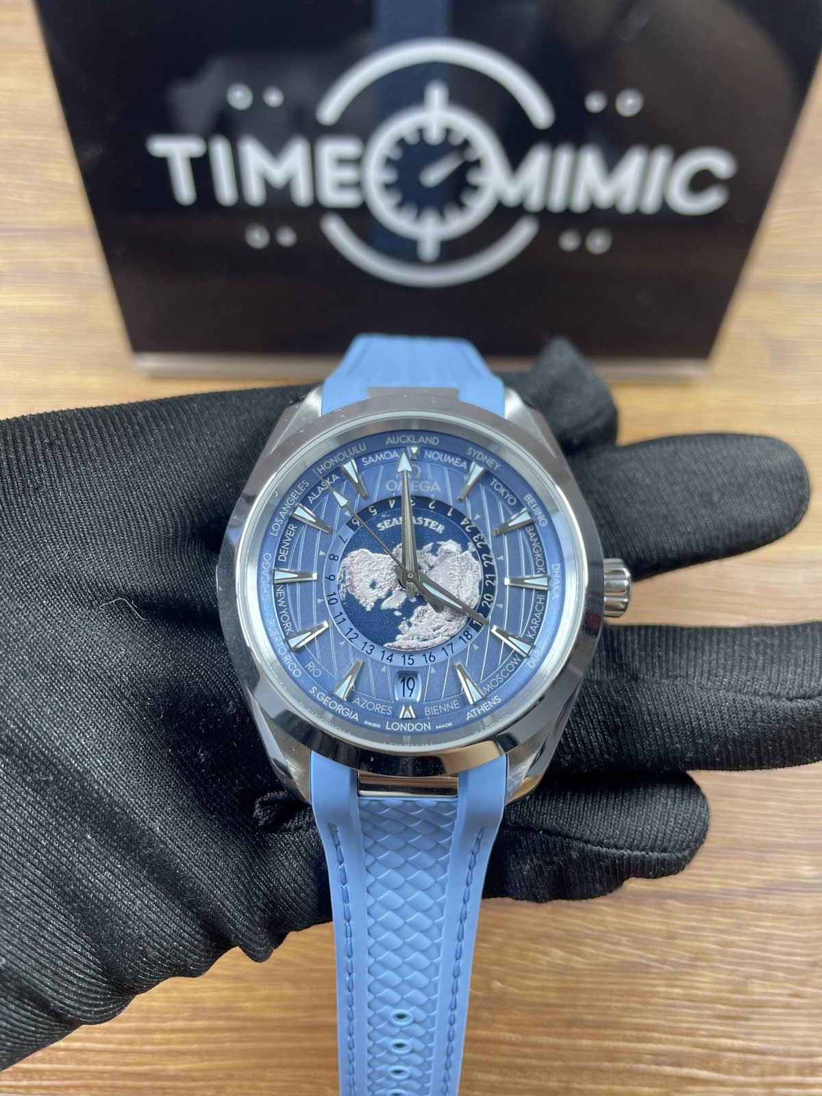 Summer Blue Aqua Terra Worldtimer replica with central Earth image city ring 24 hour scale date 19 and integrated light blue strap