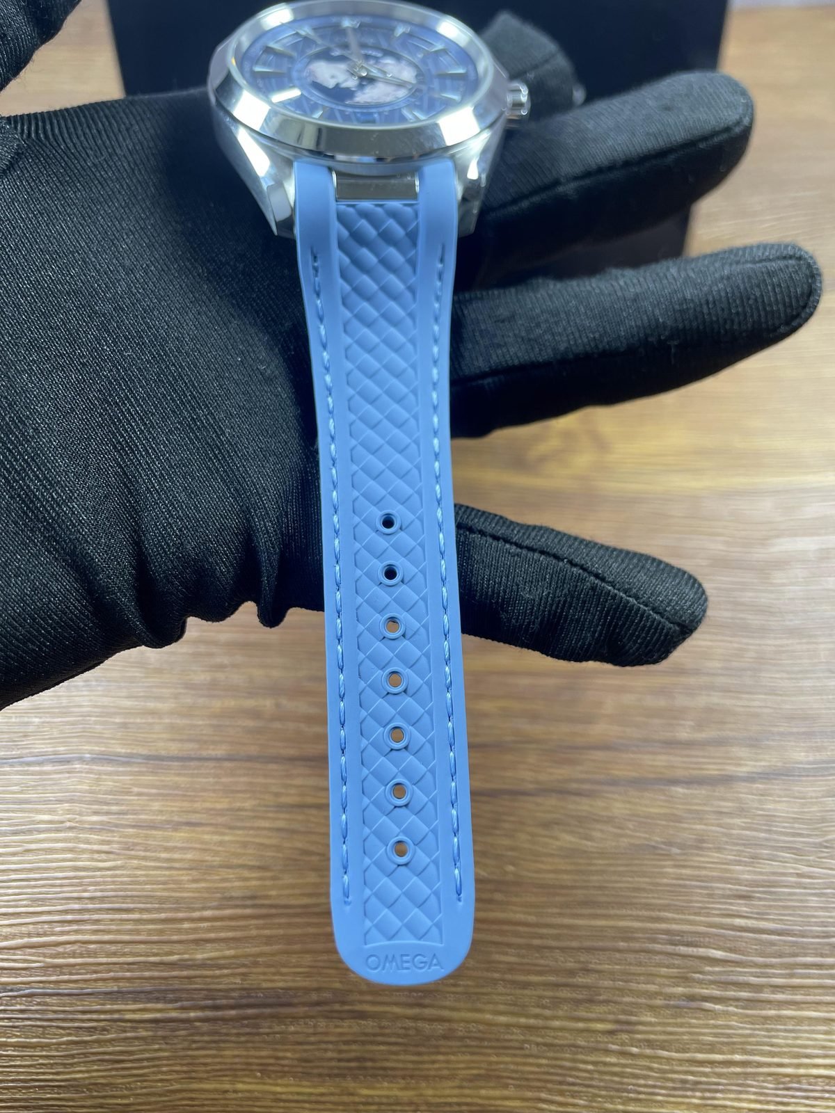Light blue woven texture rubber style strap underside with stitching holes and Omega style marks